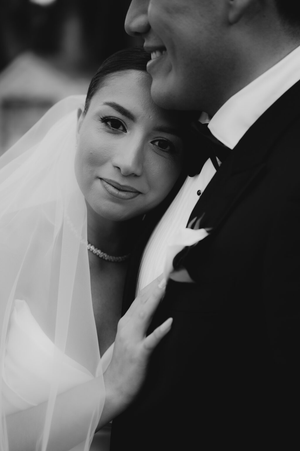 Fotografía en blanco y negro de una novia abrazada al novio durante su boda en Alicante, realizada por Castizzo, fotógrafo de bodas.